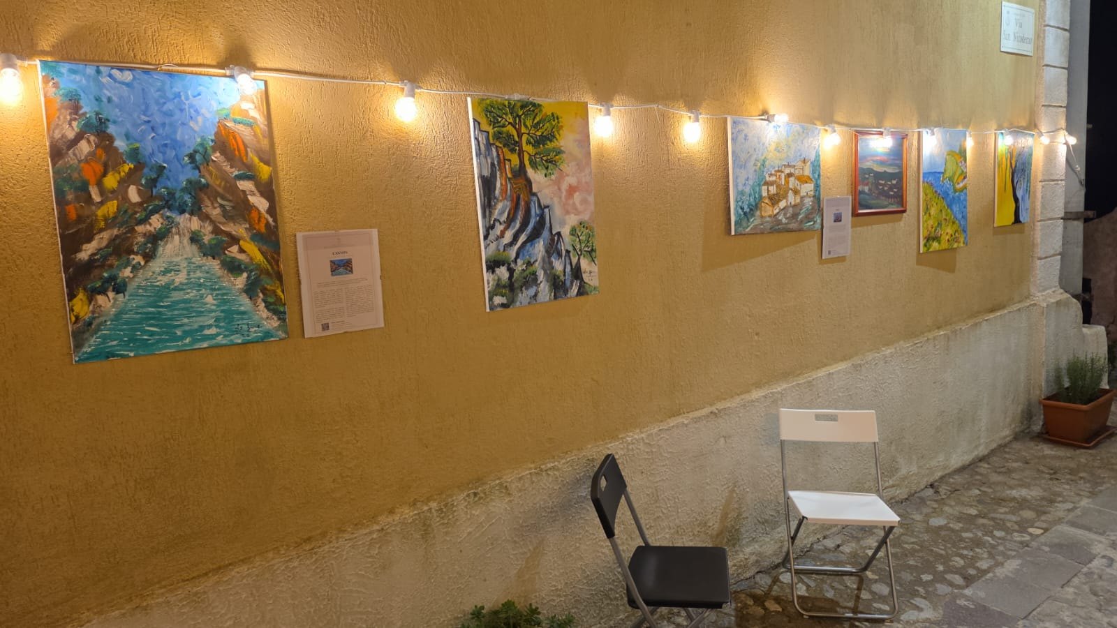 Paintings displayed outdoors during the Luce al Portello exhibition in Cirò